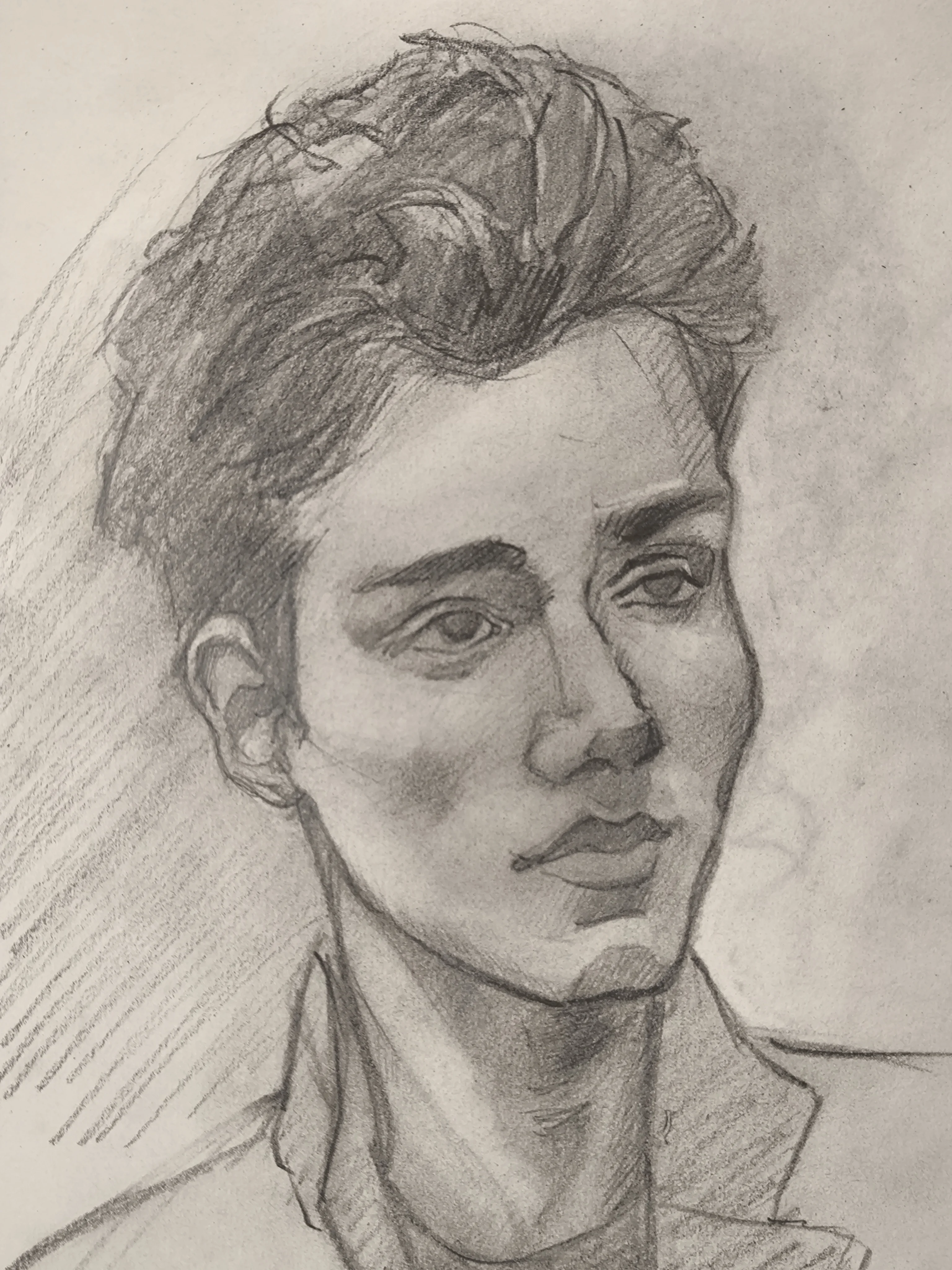 Graphite portrait sketch of a young man in three-quarter view, looking to the side. He has thick wavy hair, strong eyebrows, and soft shading on the cheek and neck, with a simple collared shirt and light hatching in the background.