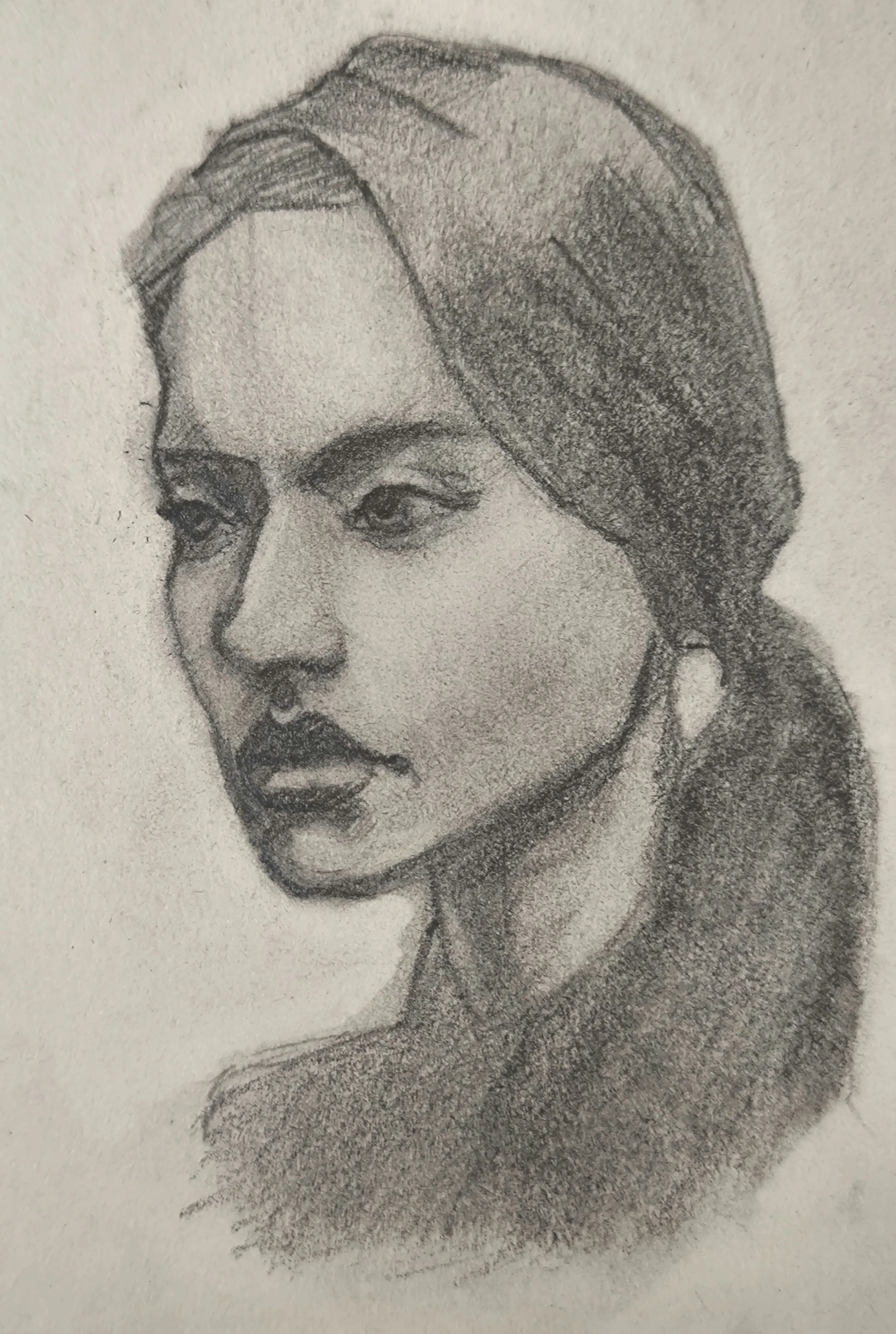 Graphite portrait sketch of a young woman in three-quarter view, looking to the left. Her hair is parted and tied back in a low ponytail, with soft shading on the face, neck, and shoulder.