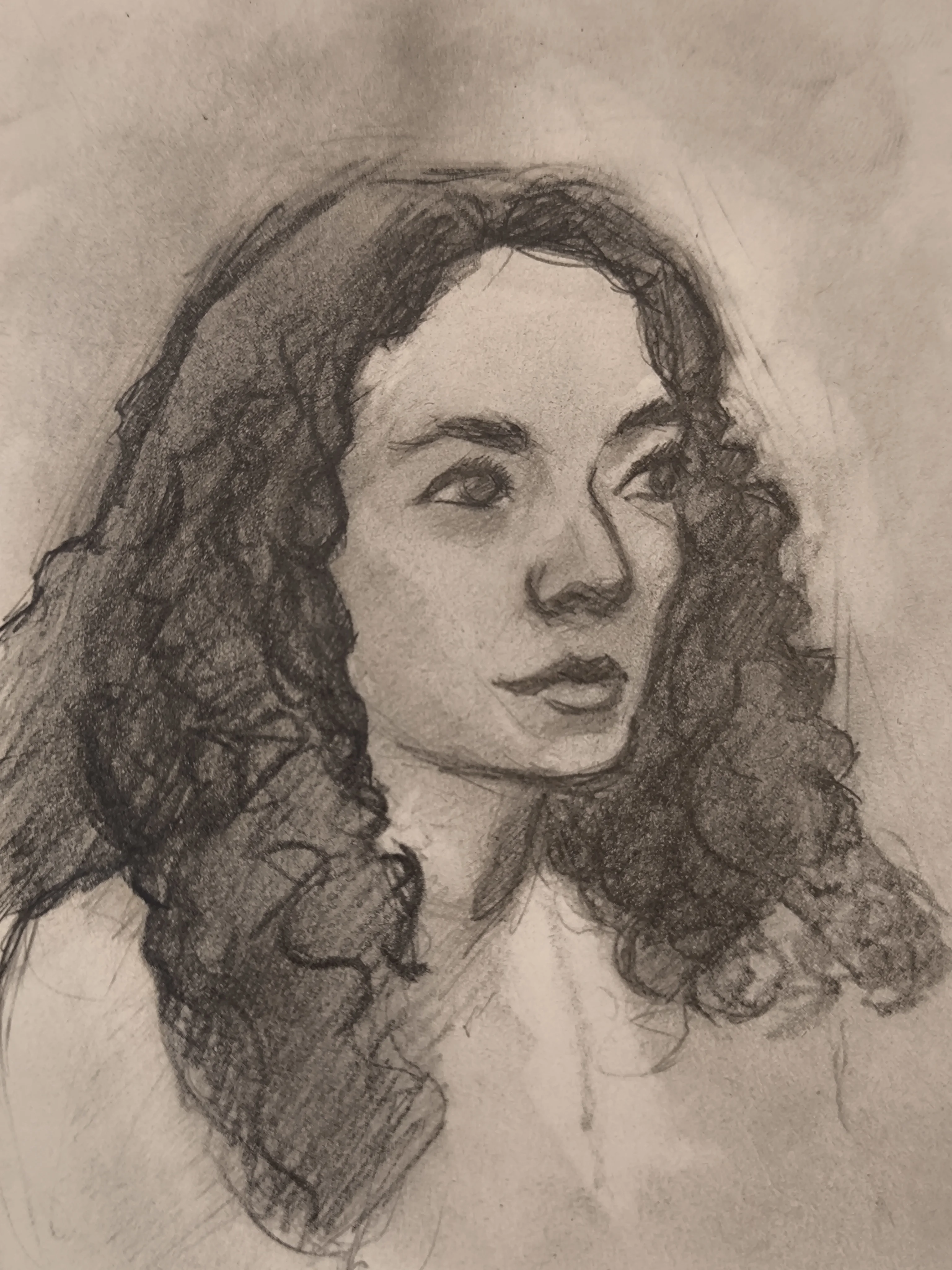 Graphite portrait sketch of a woman with long curly hair, shown from the shoulders up. She is looking to the left, with soft shading on the cheek and a darker mass for the hair.