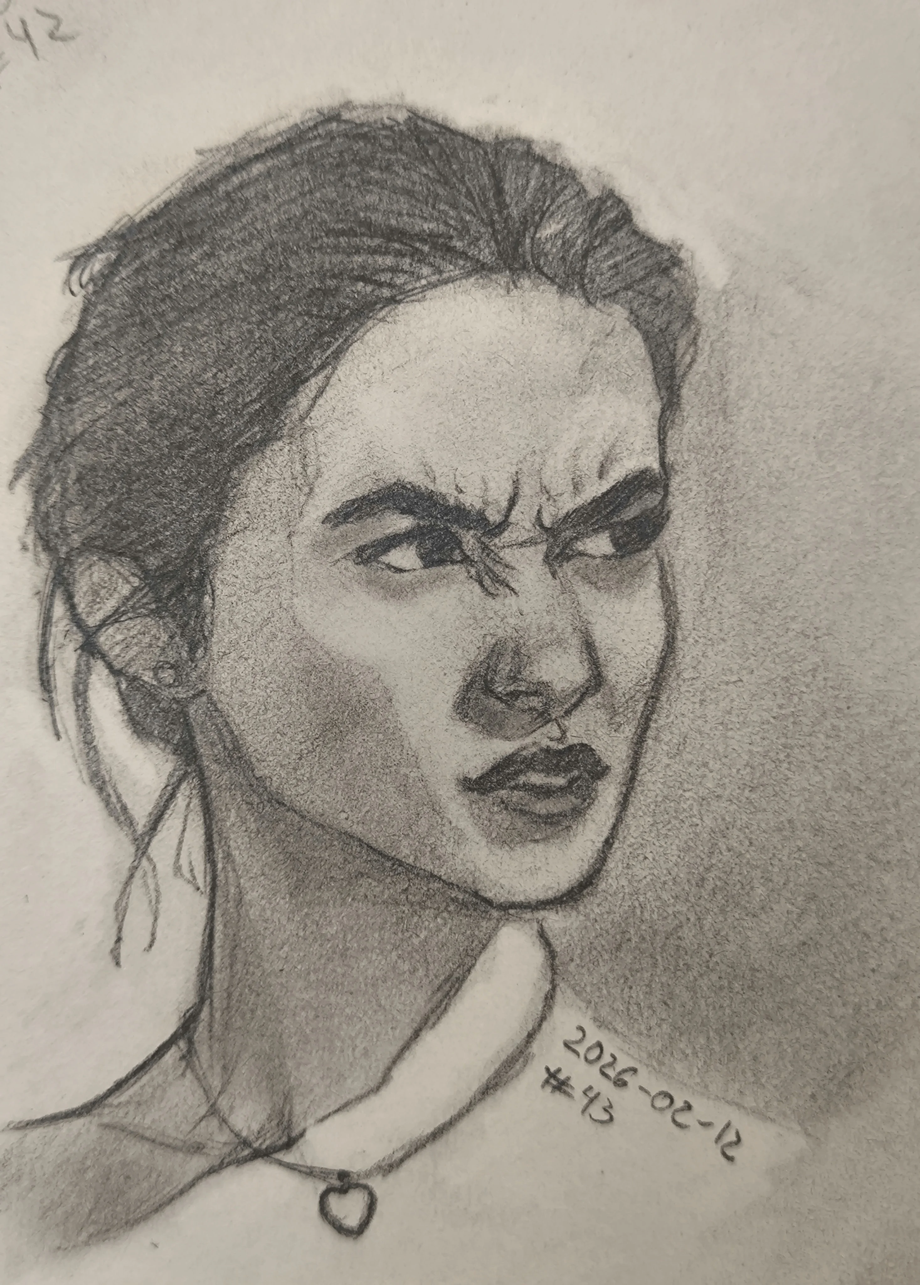 Graphite portrait sketch of a young woman in 3/4 view, looking to the side with a strong frown and furrowed eyebrows. Hair is pulled back, with loose strands near the ear. Soft shading on the cheek and neck, and she wears a choker with a small heart pendant.