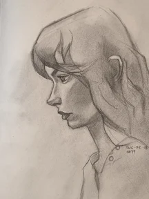 Graphite portrait sketch of a young woman in side profile, looking to the left. Soft shading on the cheek and jaw, with loose hair strands across the forehead and a simple shirt collar visible.
