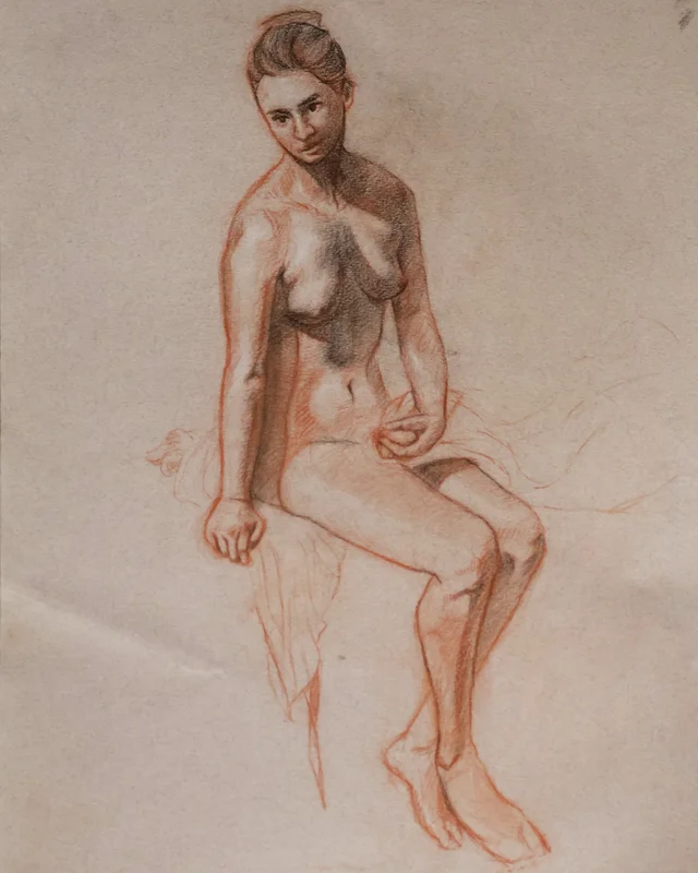 Seated nude figure study of a woman, drawn with red and dark pencil. She sits on edge with one hand resting, body slightly turned, soft shading on torso and legs.